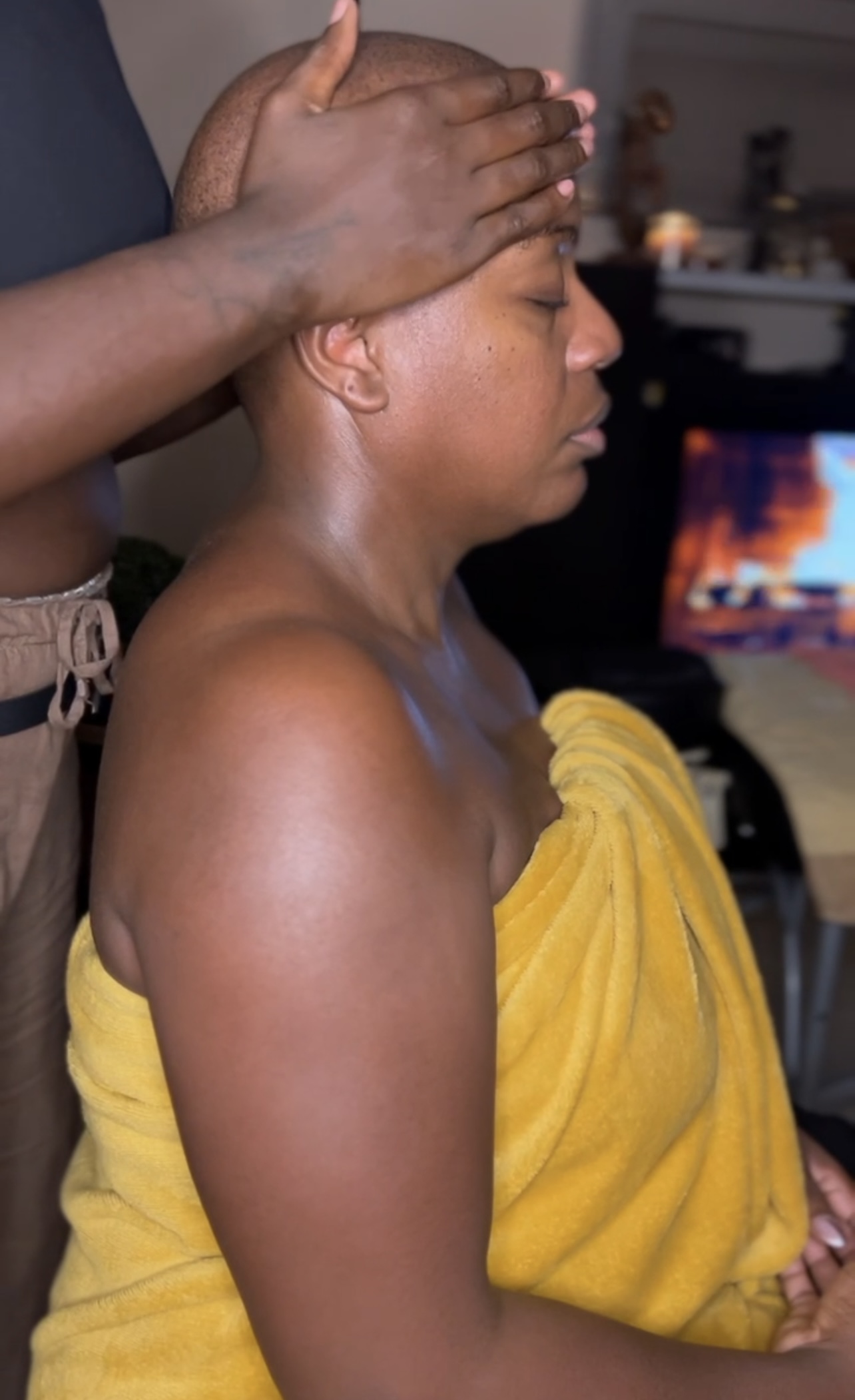 Une masseuse qui masse le crane d'une cliente